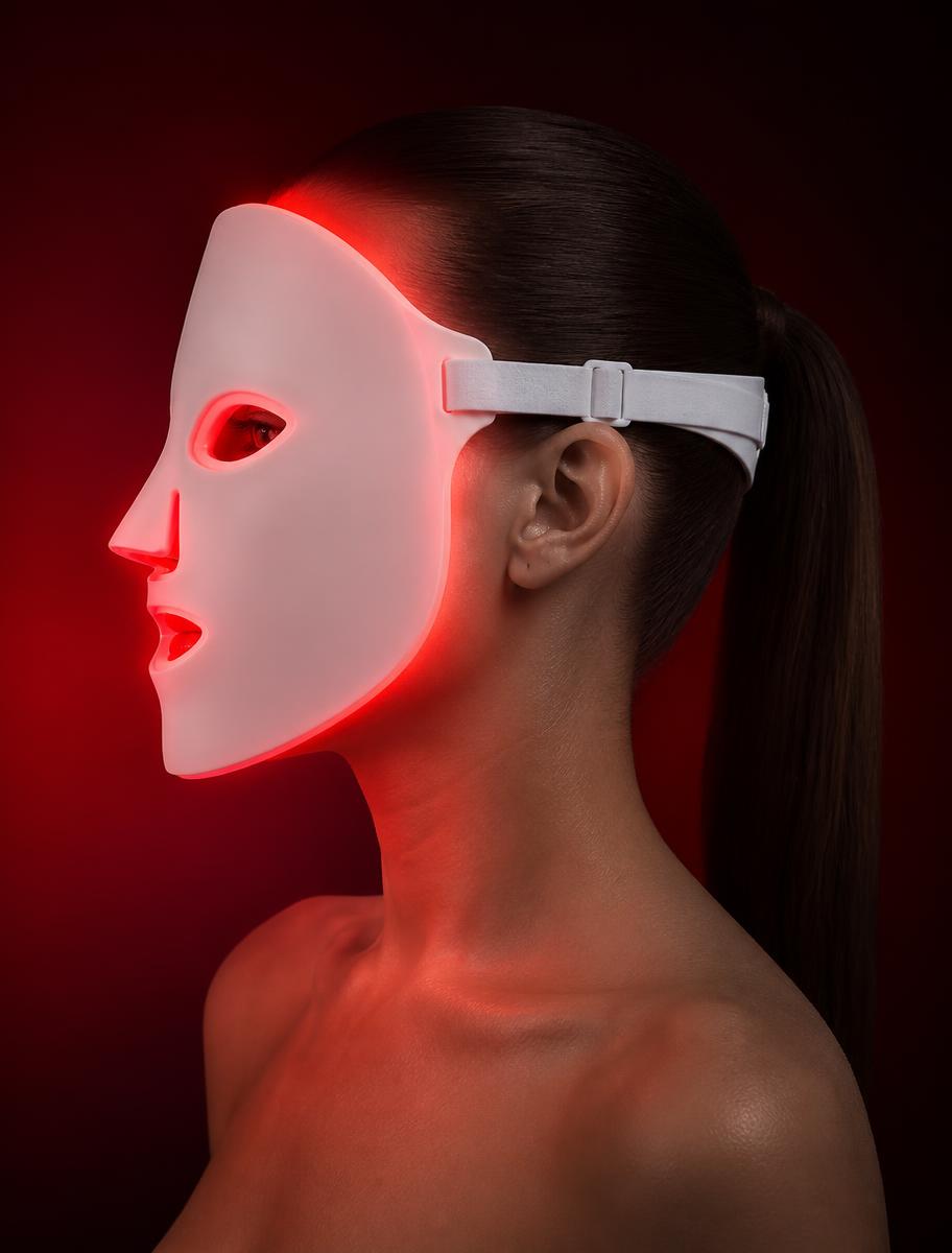 Femme de profil portant le masque LED AURINDE en lumière rouge